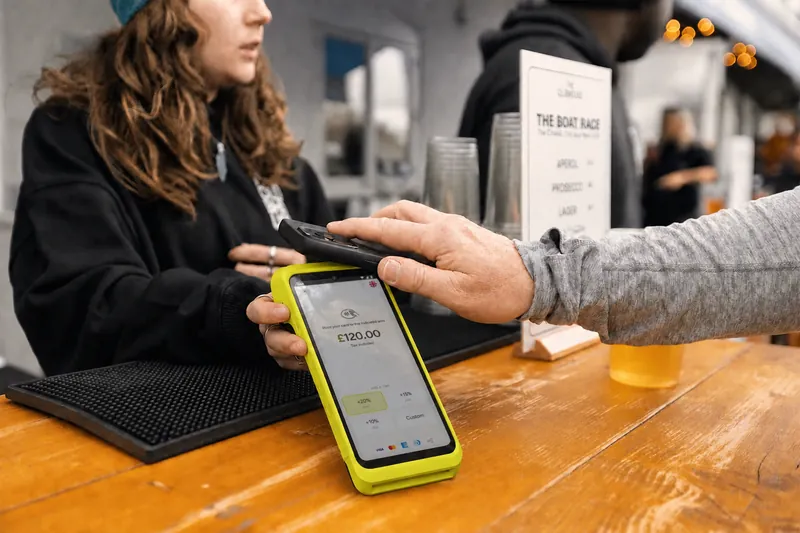 A barista handing a Teya Pro across a cafe counter